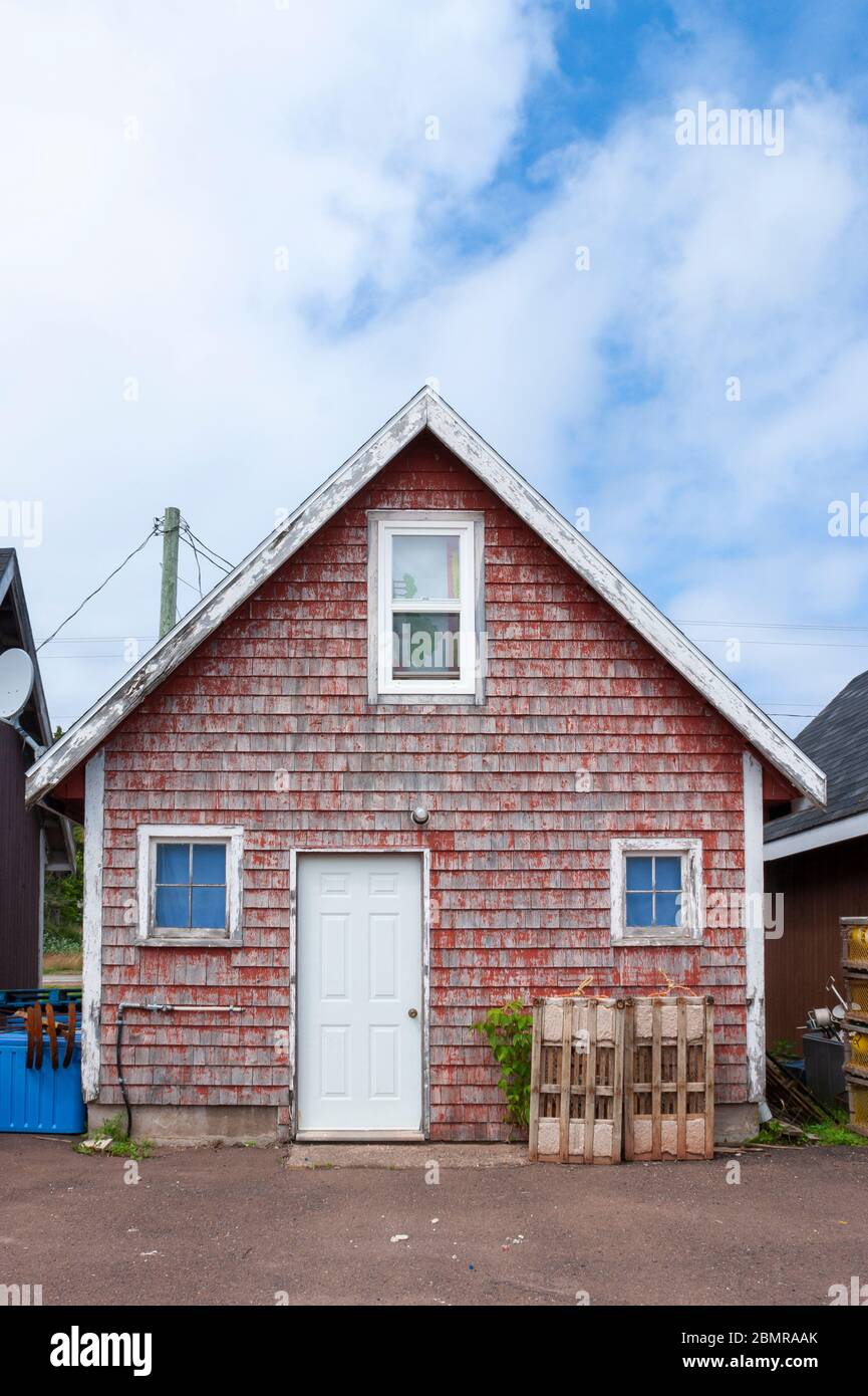 Quaint fisherman's shack, by the docks. Weathered red-painted single siding. North Rustico Harbour, Prince Edward Island, Canada Stock Photo