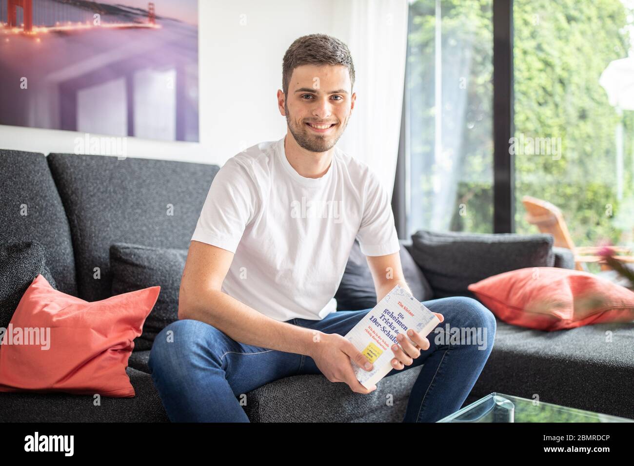 Haan, Germany. 09th May, 2020. Tim Nießner sits on a couch with his book 'The secret tricks of the 1.0 pupils'. The 18-year-old from Haan near Düsseldorf has come up with something special to prepare for his Abitur: He has interviewed almost 100 of the best high school graduates in Germany to find out what he can learn from them. This has resulted in a 300-page book entitled: 'Die geheimen Tricks der 1,0er-Schüler' (The Secret Tricks of the 1.0 Students), which will be published by mvg Verlag on 12.05.2020. Credit: Marcel Kusch/dpa/Alamy Live News Stock Photo