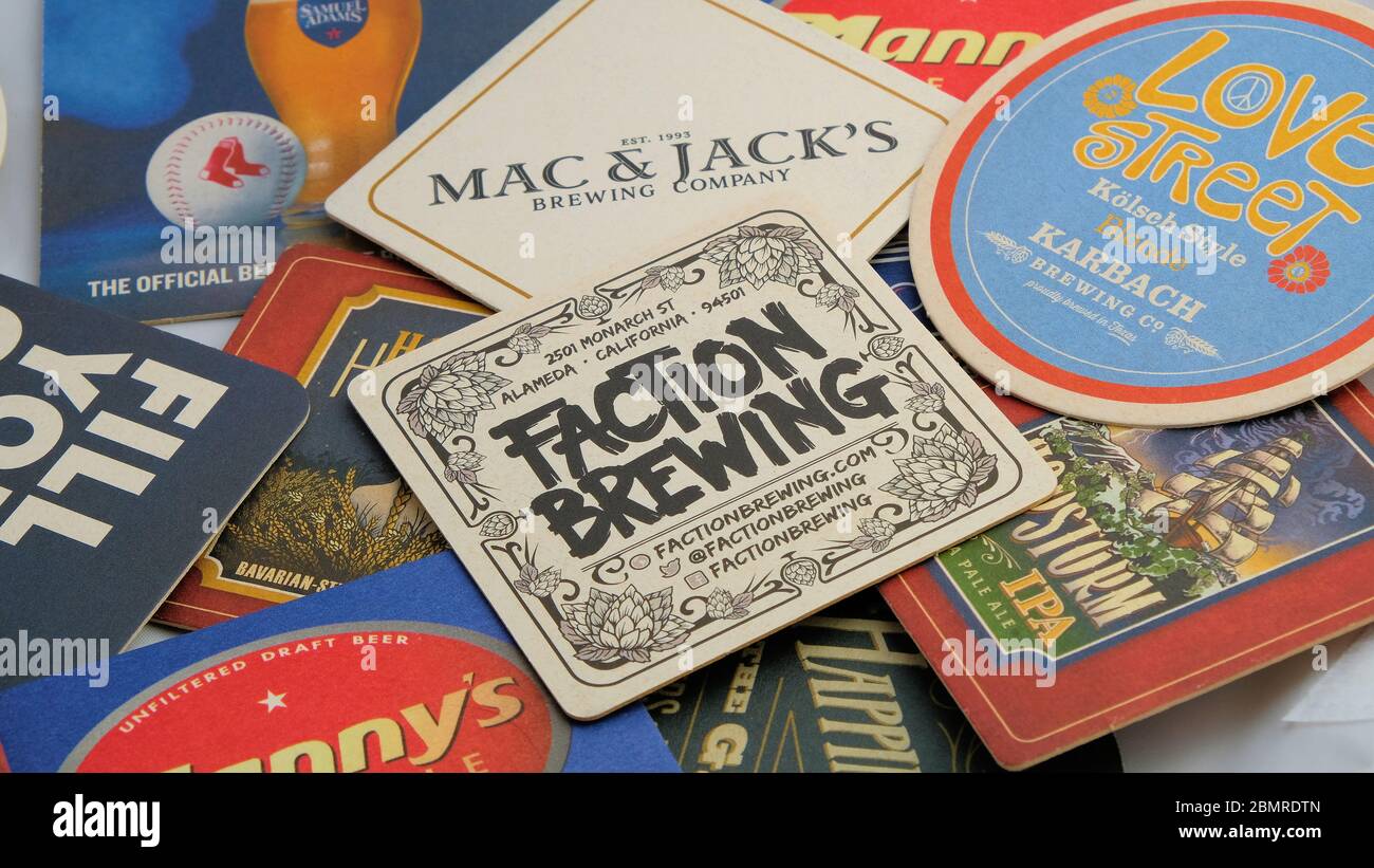 Assorted beer coasters or mats featuring American brews; Faction Brewing, Karbach, Mac & Jack's, Amstel. Stock Photo