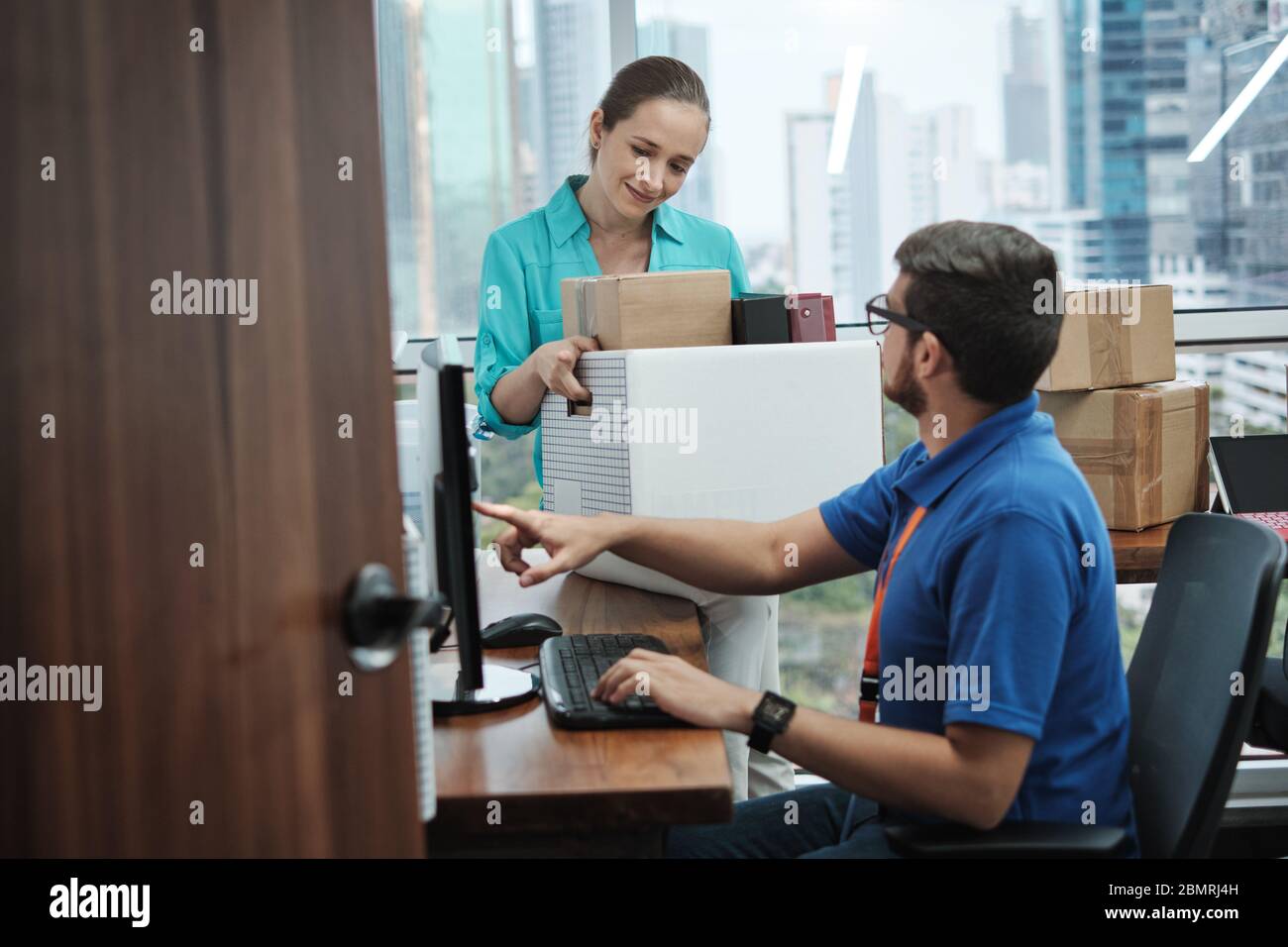 IT Expert Setting Computer To Woman Moving Into New Office Stock Photo