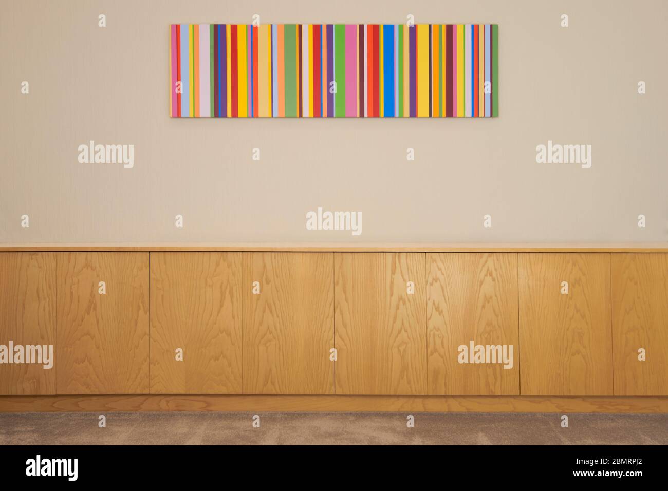 Painting hanging on a wall above a fitted sideboard Stock Photo Alamy