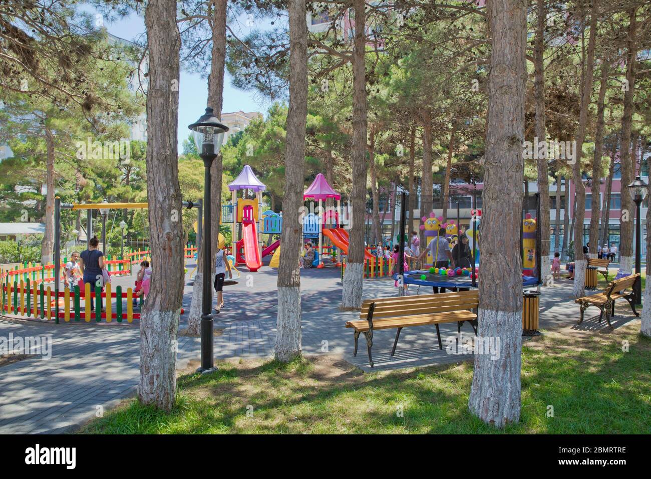 Children kids playground with play equipment outdoor. Kids playground with slides in the park. Pine trees . play ground colorfull big plastic toy set Stock Photo