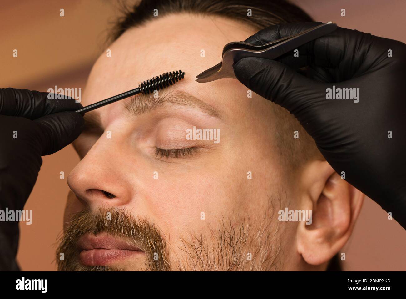 Professional barber doing threading procedure and correcting shape of