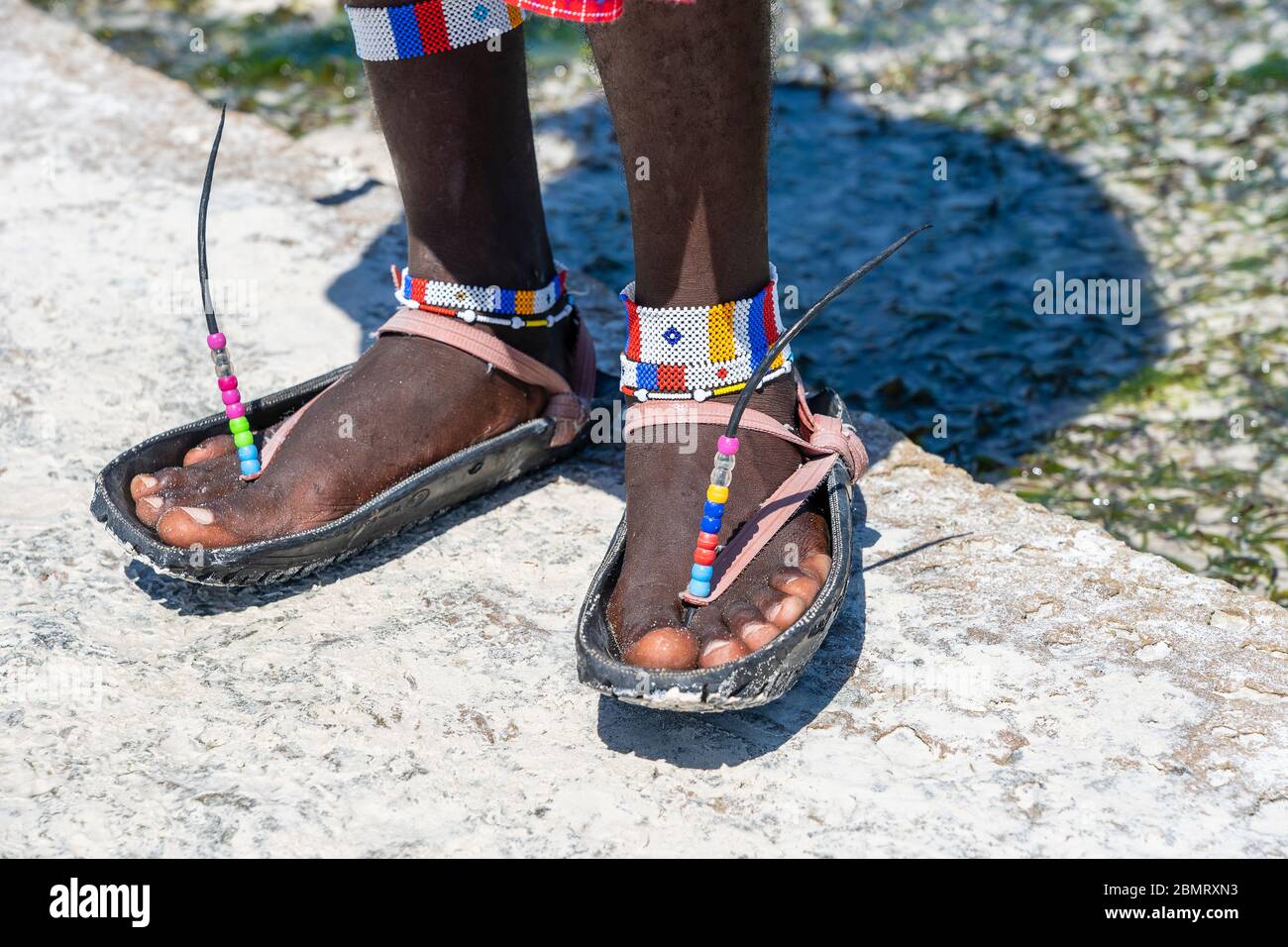 masai legs with a colorful bracelet and sandals made of car tires on the sand beach, close up. Island of Zanzibar, East Africa Stock Photo - Alamy