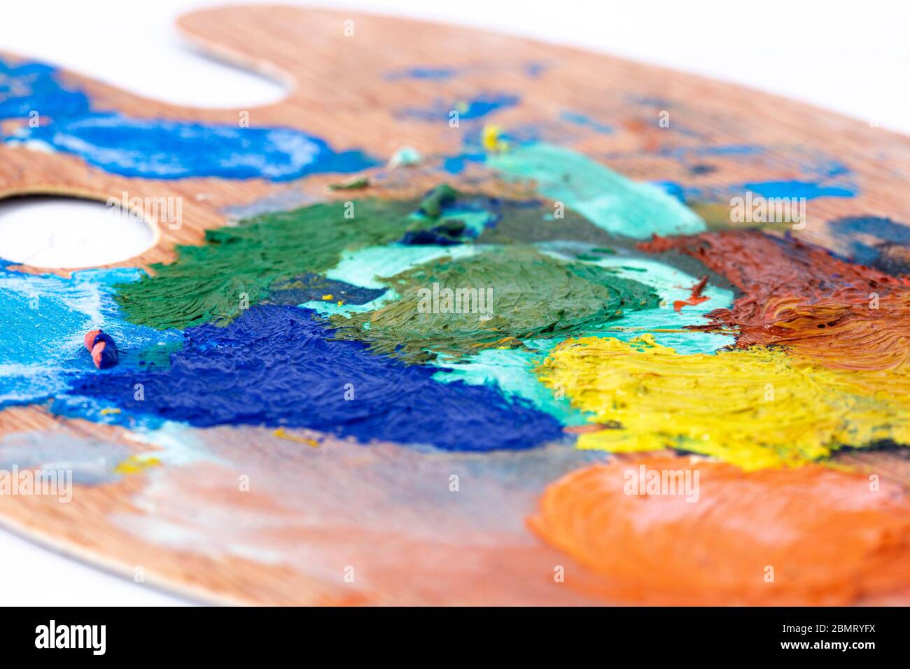 Artist oil paint wooden palette, with mixed paint colours mixed. Art and craft supplies concept