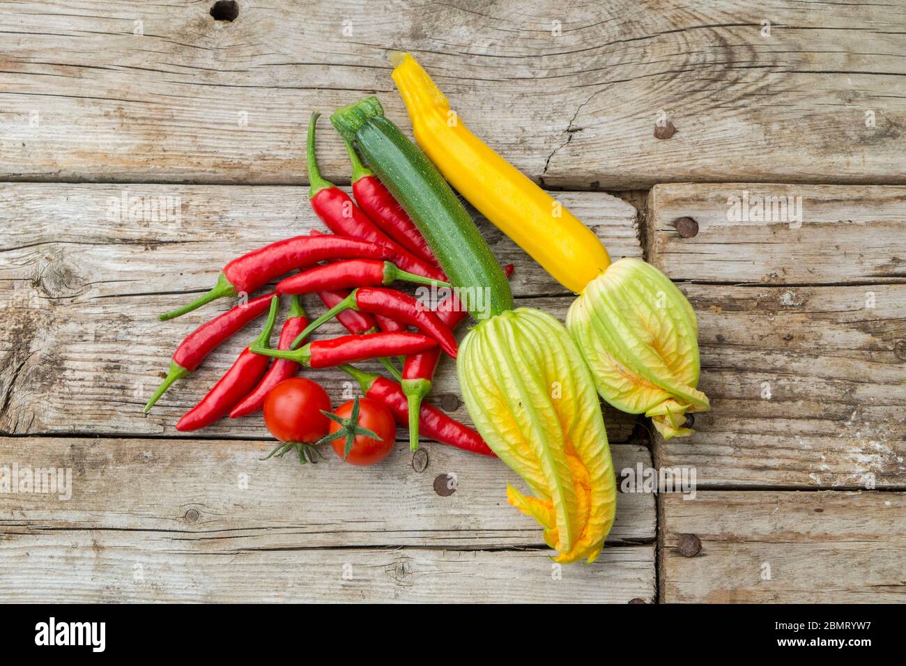 Home grown baby courgettes, chillies and tomatoes. Stock Photo