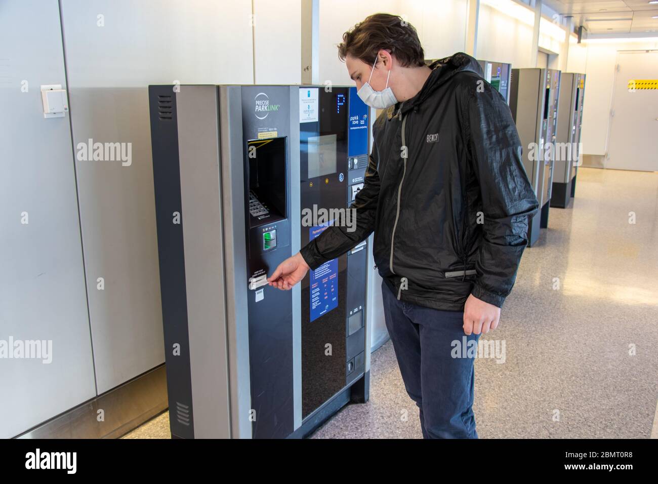 Man wearing masks pays for parking at Toronto Pearson International