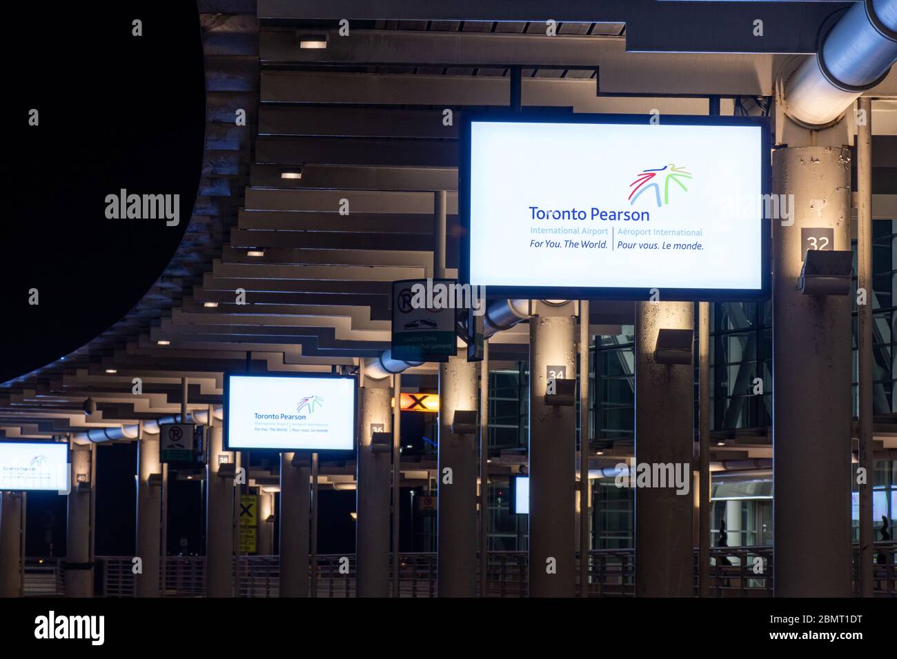 Toronto Pearson International Airport logo seen on digital screens outside Terminal 1 at night. Stock Photo