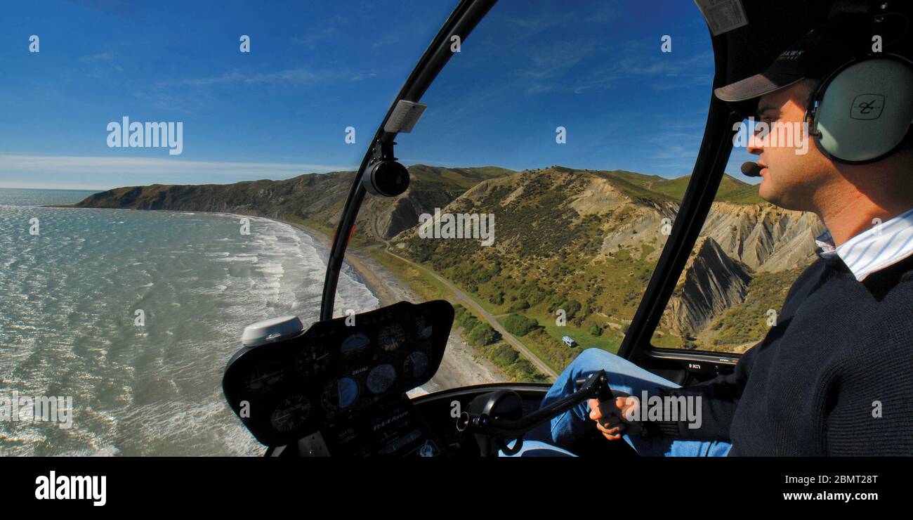 A cockpit panorama view of a Robinson R44 helicopter over the Marlborough coastline near Point Campbell, New Zealand. Stock Photo