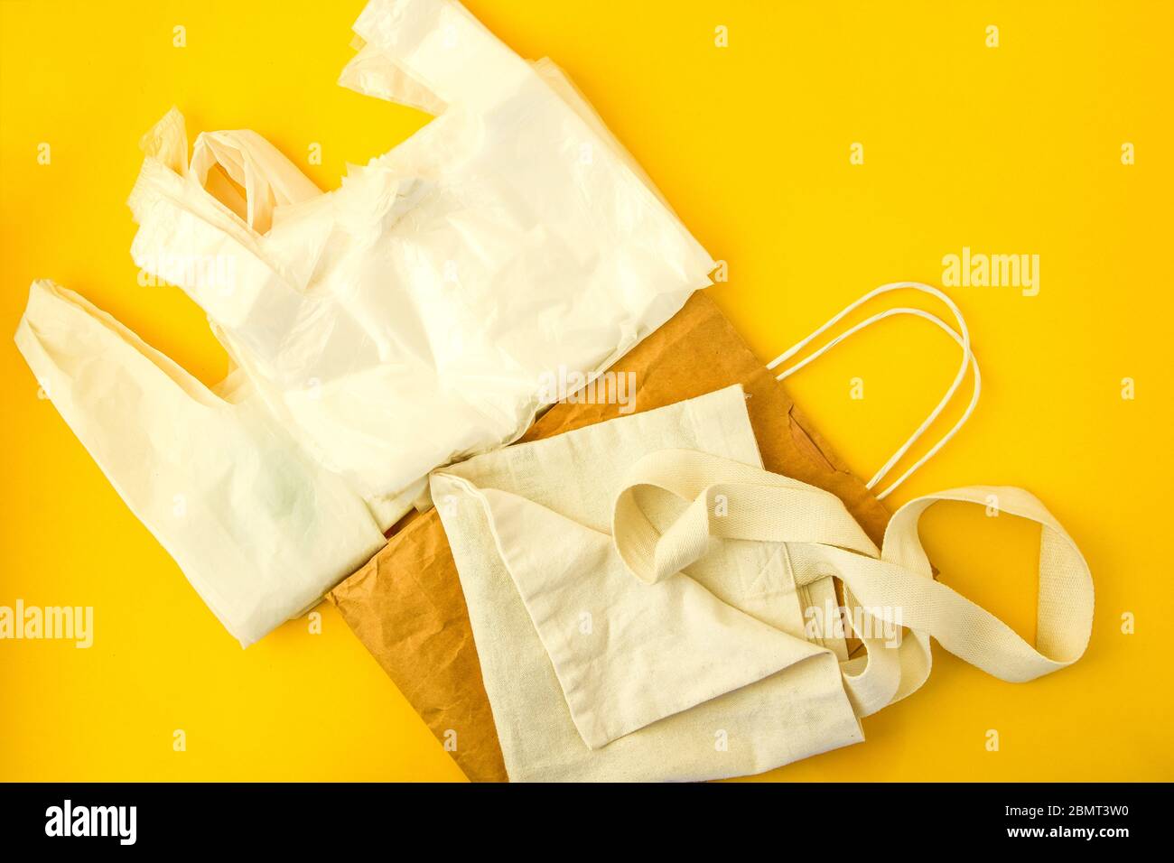 Clear disposable plastic bag on yellow background vs eco tote bags