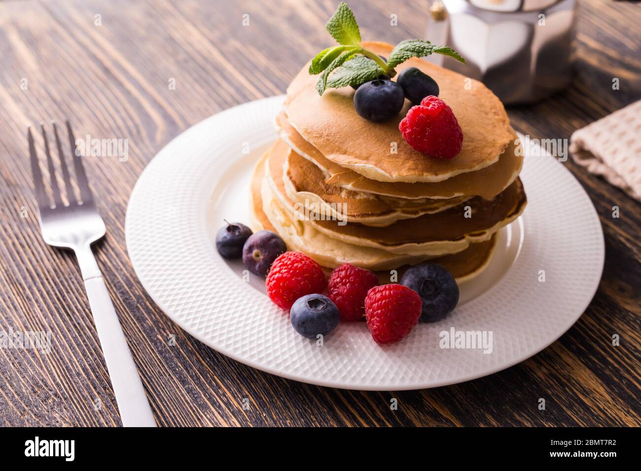 Pancakes with blueberries and raspberry on wooden background. Breakfast ...