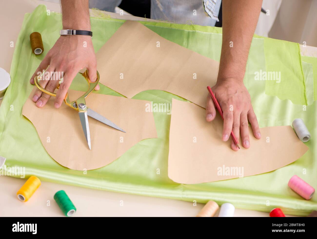 The young handsome tailor working in his workshop Stock Photo - Alamy