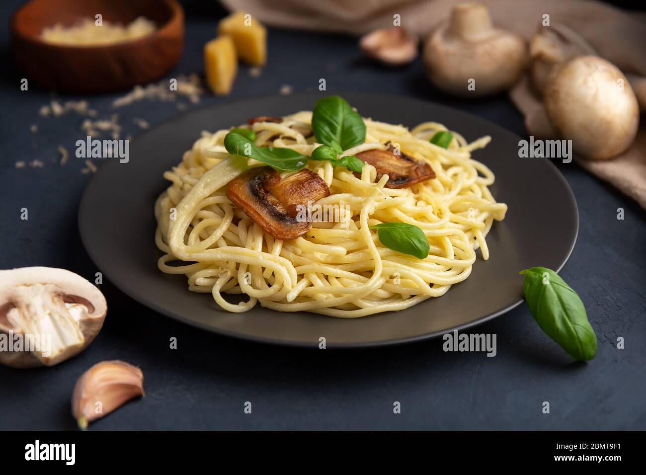 Italian pasta with mushrooms and cheese on a dark background. Close-up Stock Photo