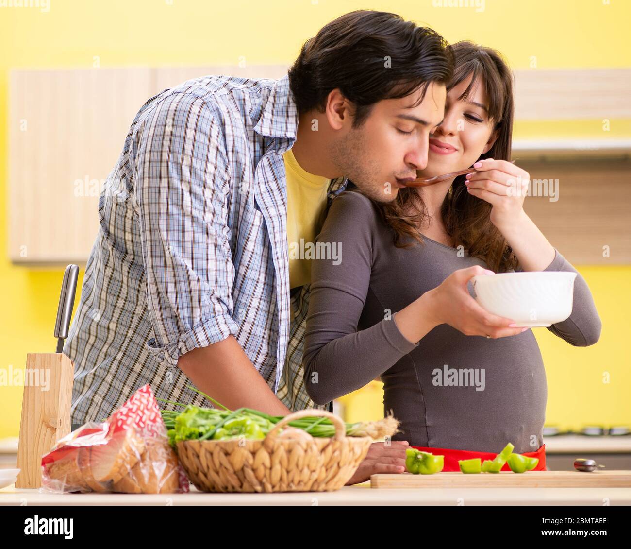 The man and pregnant woman preparing salad in kitchen Stock Photo - Alamy