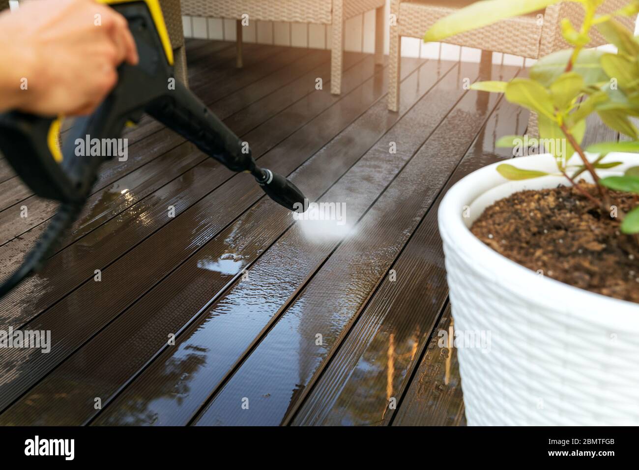cleaning wooden terrace planks with high pressure washer Stock Photo