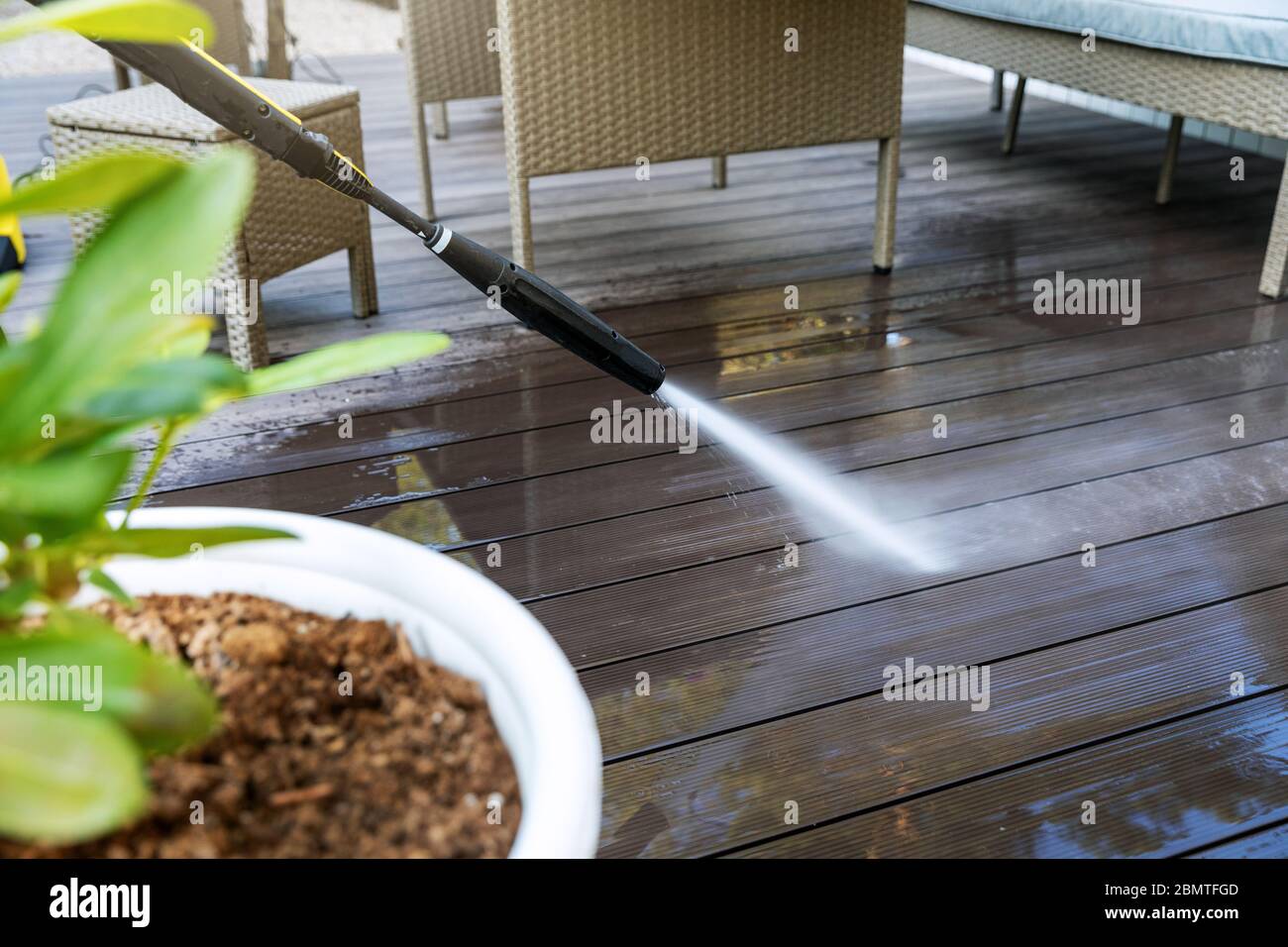 cleaning wooden terrace planks with high pressure washer Stock Photo