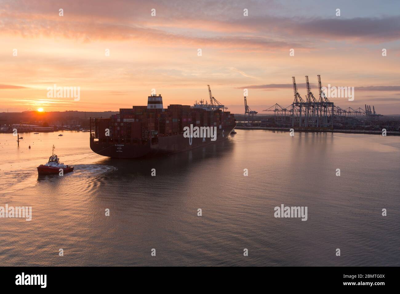 City of Southampton, England. Picturesque sunset view of a container ship navigating the River Test at Southampton Docks. Stock Photo