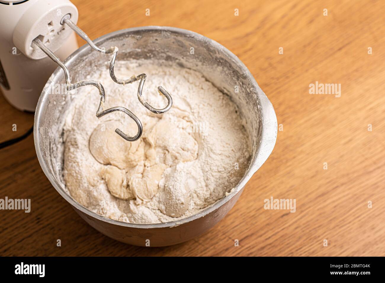 https://c8.alamy.com/comp/2BMTG4K/hand-mixer-and-a-metal-bowl-with-dough-2BMTG4K.jpg