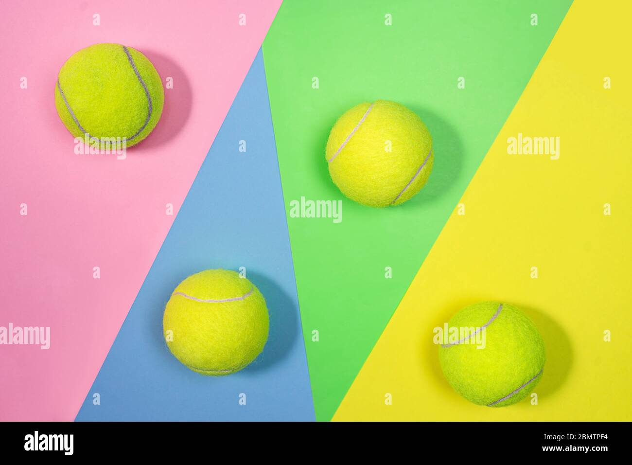 Tennis layout with tennis balls on abstract pastel pink blue yellow green  multicolored background with place for text. Sport concept with tennis  play. Flat lay, top view, selective focus Stock Photo -