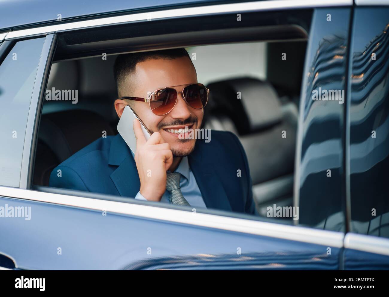 Young successful businessman driving in his new car.Business and travel