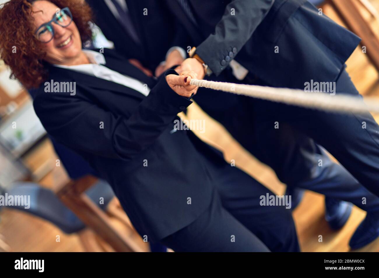 Business workers stretching rope at the office Stock Photo - Alamy