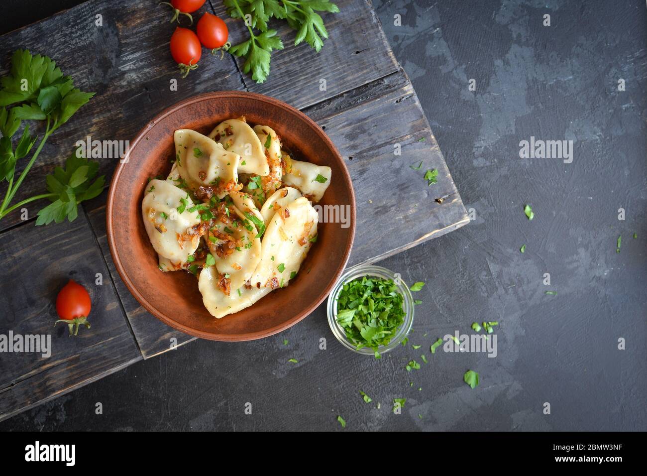 Dumplings with potato filling. Dumplings in a clay plate. Top view. Free space for text. Stock Photo