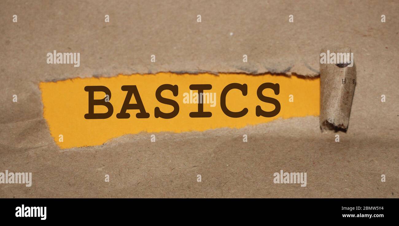 The word Basics appearing behind torn brown paper. Education concept Stock Photo