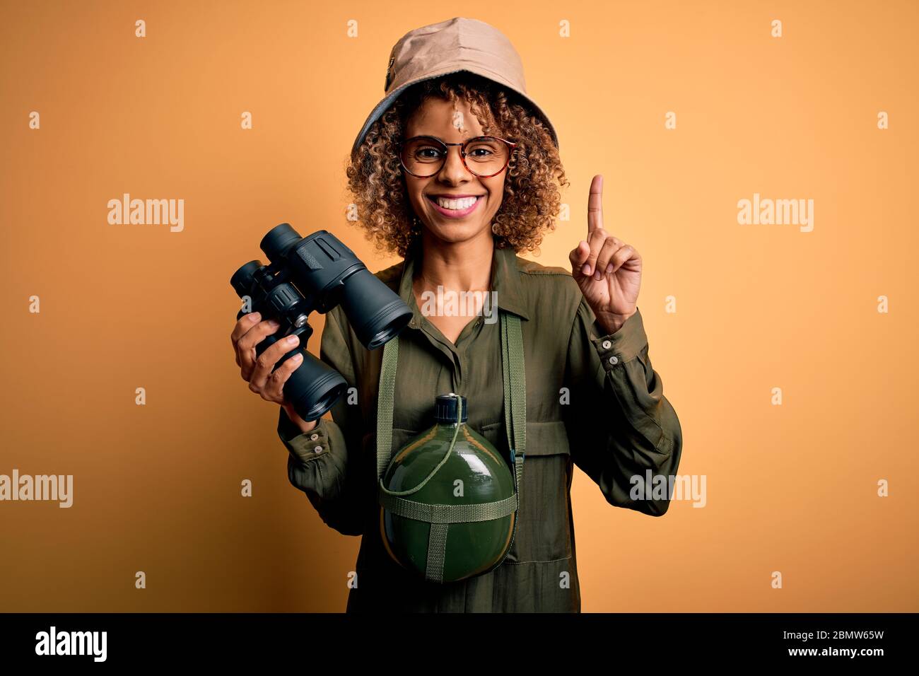 African american tourist woman wearing explorer hat and water canteen ...