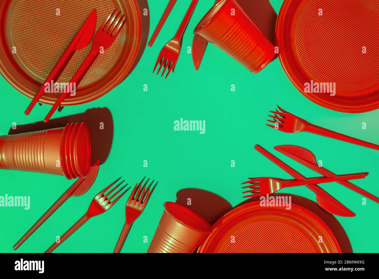 Red Plasticware Red disposable plastic tableware, plate, cups, knife and spoon on mint ...