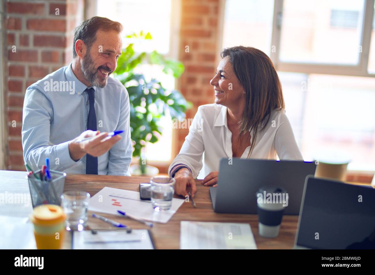 Two middle age business workers smiling happy and confident. Working ...