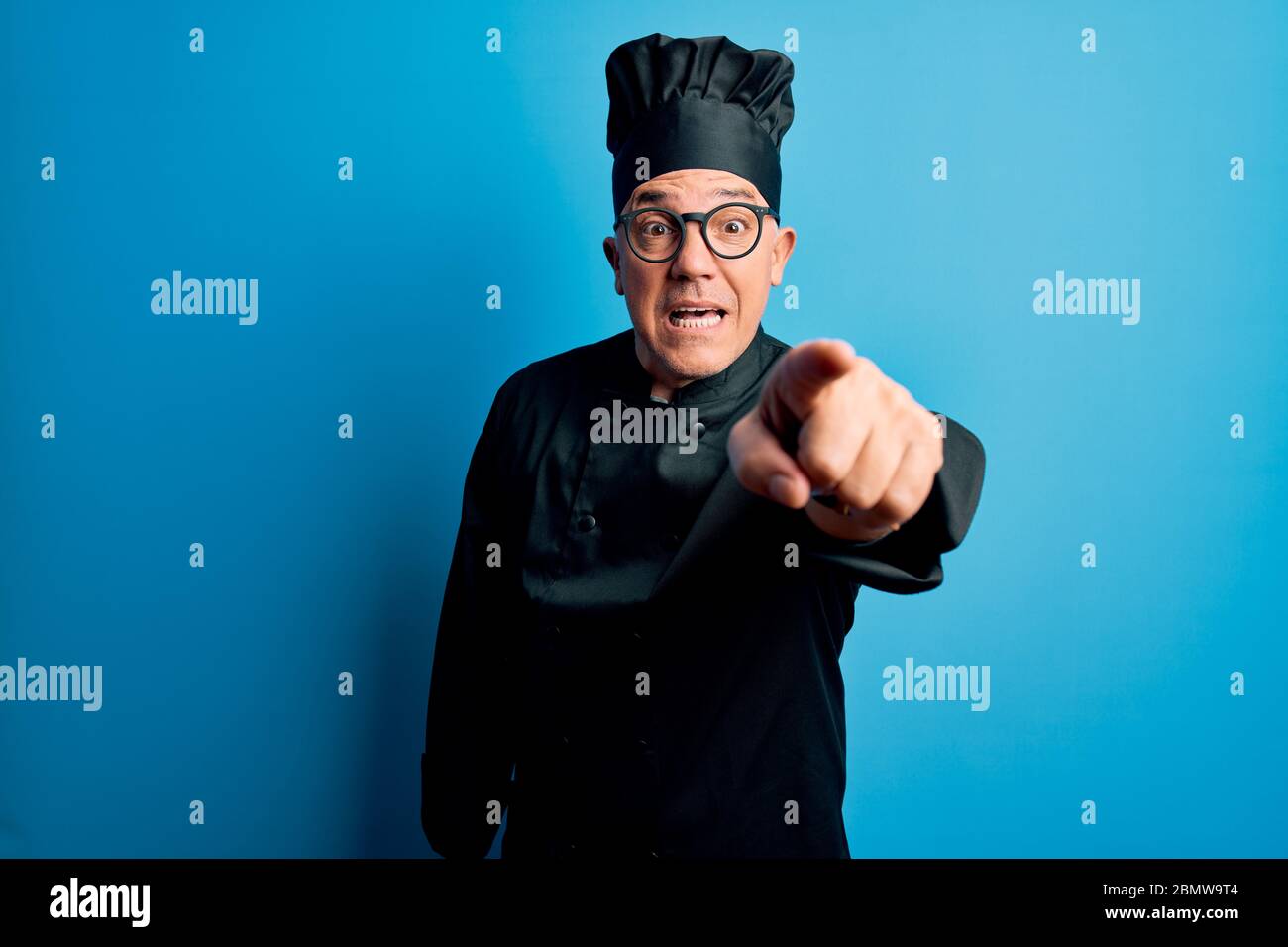 Middle age handsome grey-haired chef man wearing cooker uniform and hat ...