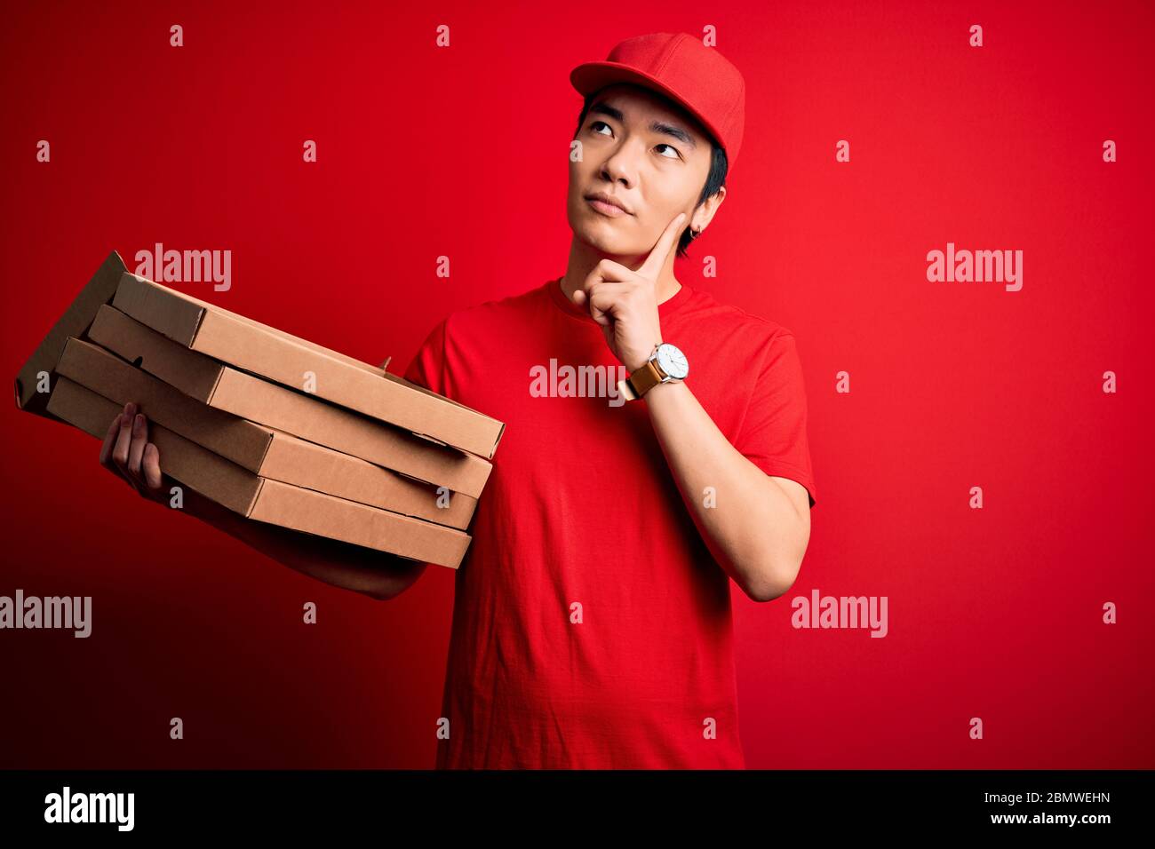 Young handsome chinese delivery man holding deliver boxes with Italian
