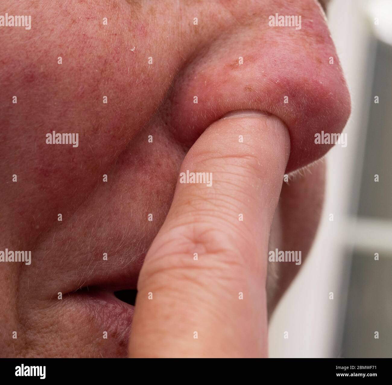 Woman with finger up her nose Stock Photo
