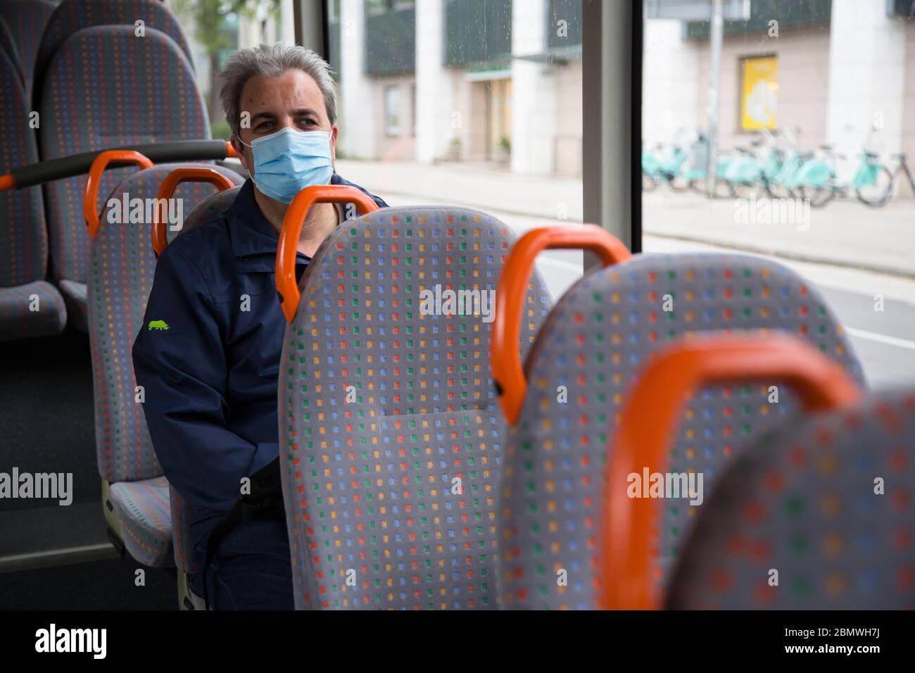 A man inside a bus wearing a face mask as a preventive measure as public transport resumes under strick safety measures.Public transport in Slovenia resumed after two months of Coronavirus (COVID-19) lockdown. Stock Photo