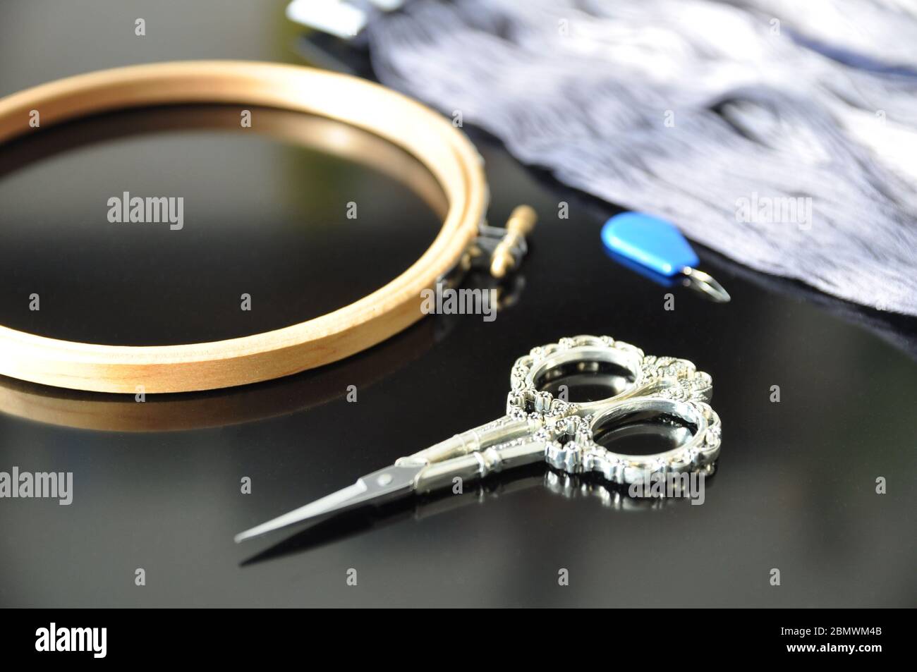 Sewing needle threader tool in use and a single black string Stock Photo -  Alamy