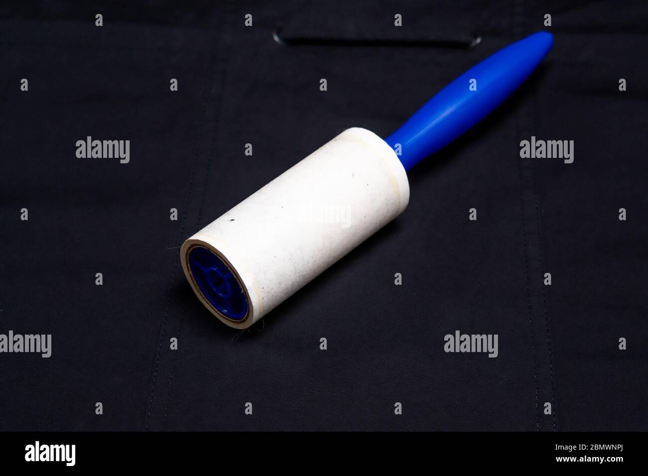 Adhesive roller for cleaning cloth on a black cloth Stock Photo