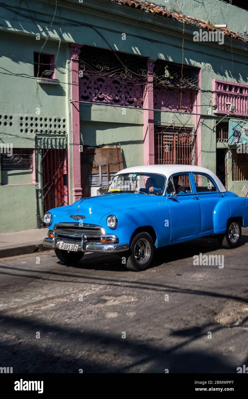 Vintage car driving down famous Neptuno Street, Havana Centro district, Havana, Cuba Stock Photo