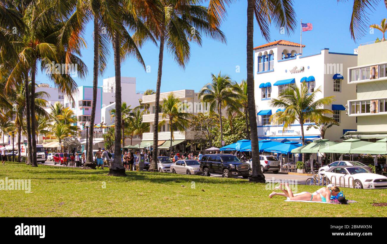 Lummus park, Ocean drive, Miami beach, Florida, USA - 9th Mar, 2015. Two women sunbathing on public lawn adjacent to busy road on hot spring day. Stock Photo