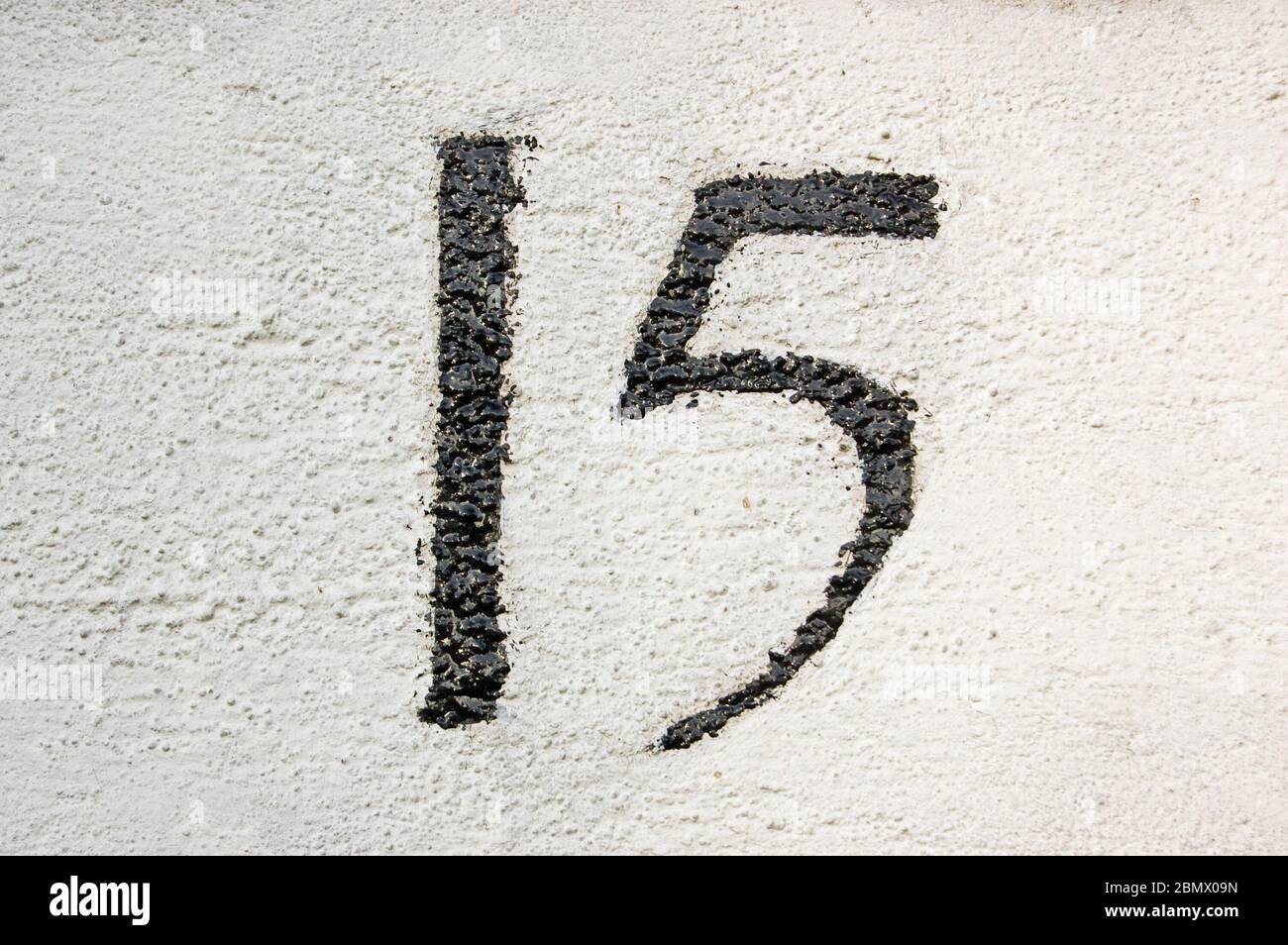 Number fifteen painted on the wall outside a house in London. Stock Photo