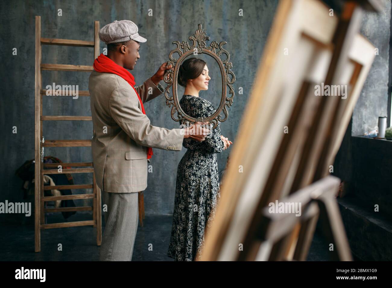 Portrait painter holds frame, female model Stock Photo