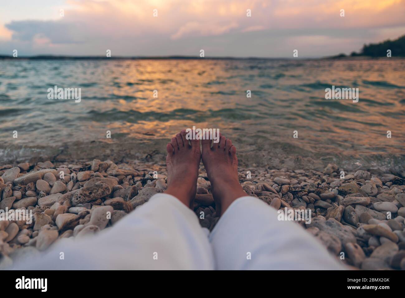 woman laying at the beach looking on sunset above sea Stock Photo - Alamy
