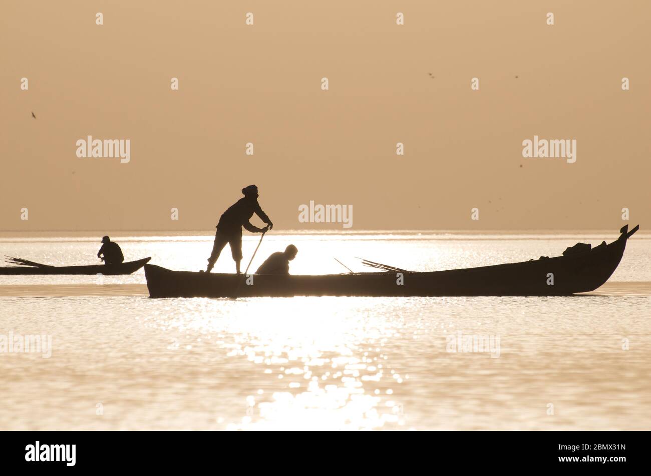 fishermen return home as the sunsets behind them on the newly flooded marshes in Southern Iraq. 2010 Stock Photo