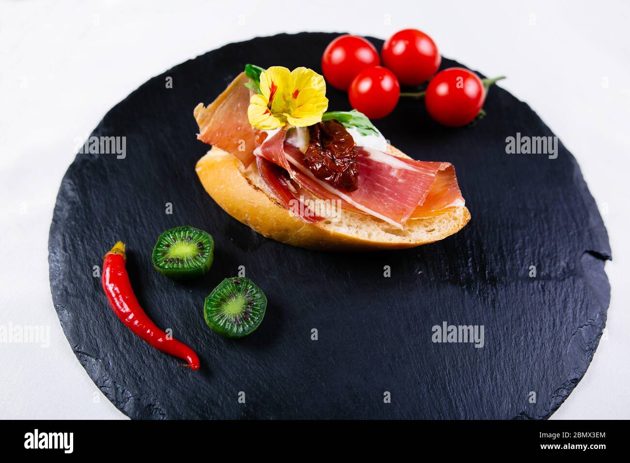 Spanish food tapas. Toasted bread with goat cheese and serrano ham ...