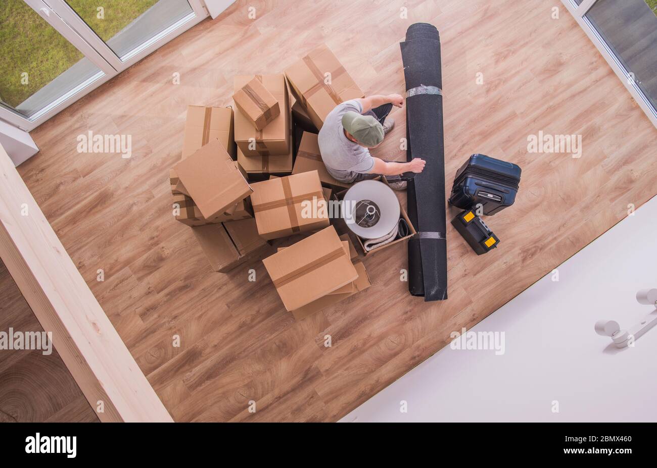 Eagle View Of Mover Male With Packed Boxes And Household Items. Stock Photo