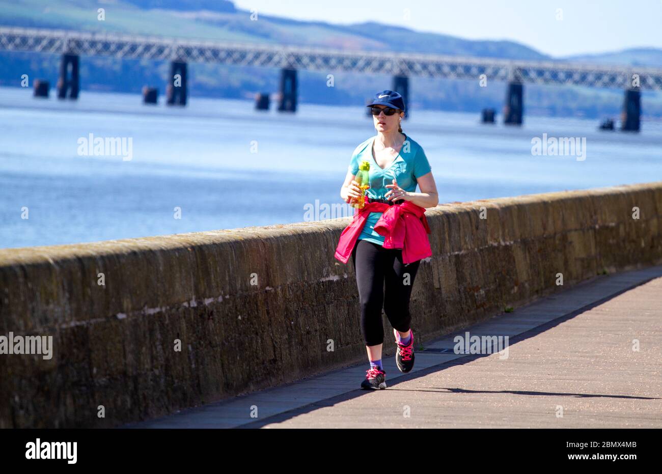 Dundee, Tayside, Scotland, UK. 11th May, 2020. UK Weather: A cooler day with sunshine in Dundee Scotland with maximum temperature 12°C. Local residents enjoying the weather while taking light outdoor exercises jogging along the riverside promenade during the Covid-19 lockdown restrictions. Credit: Dundee Photographics/Alamy Live News Stock Photo