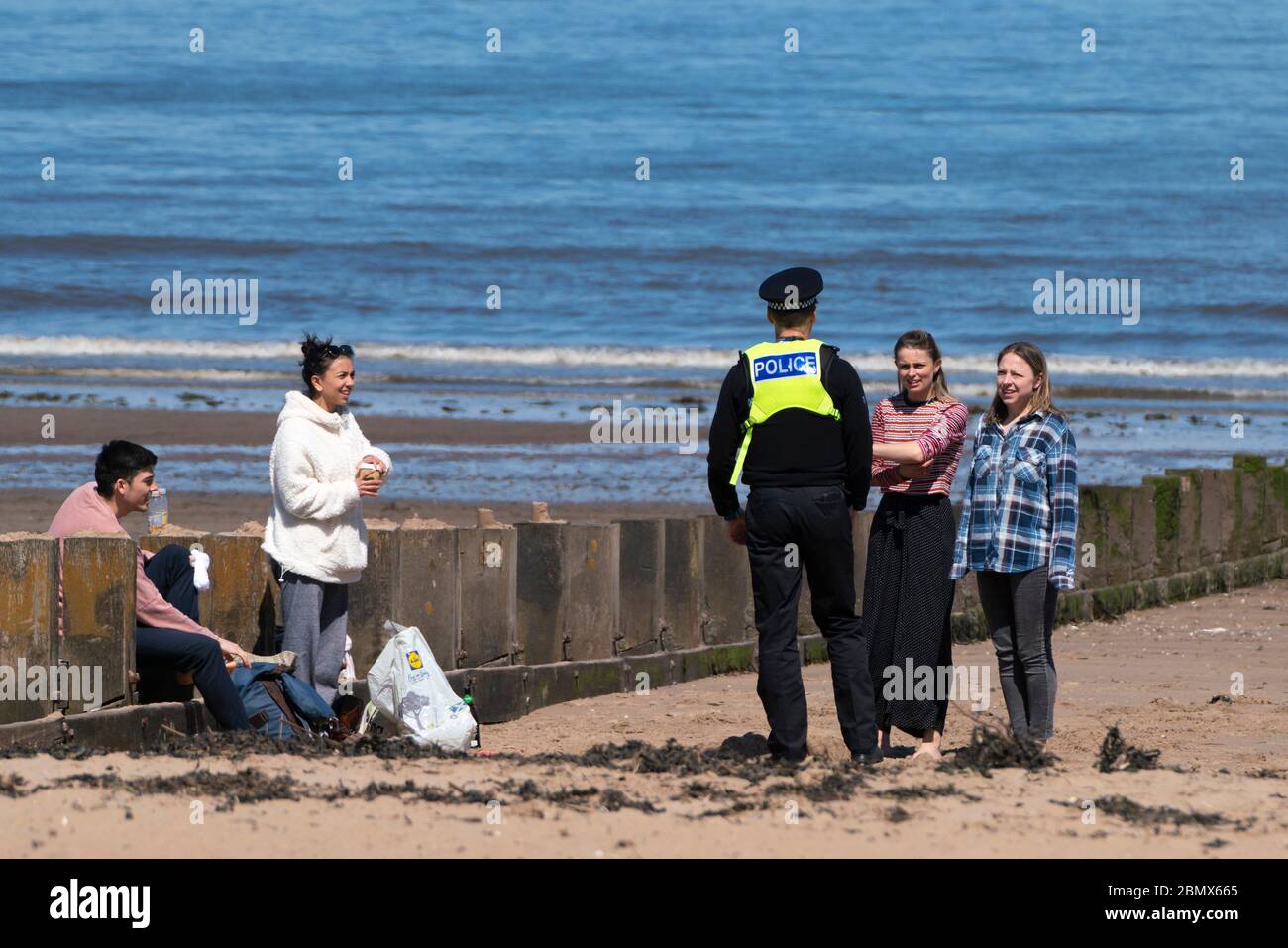 Portobello, Scotland, UK. 11 May 2020. Police patrolling promenade and beach at Portobello this afternoon in warm sunny weather. They spoke to the public who were sitting on the beach or on sea wall asking them to keep moving. Iain Masterton/Alamy Live News Stock Photo