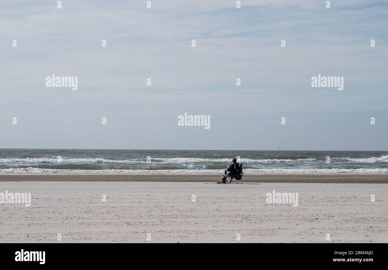 One person sitting on beach, Avalon, New Jersey Stock Photo