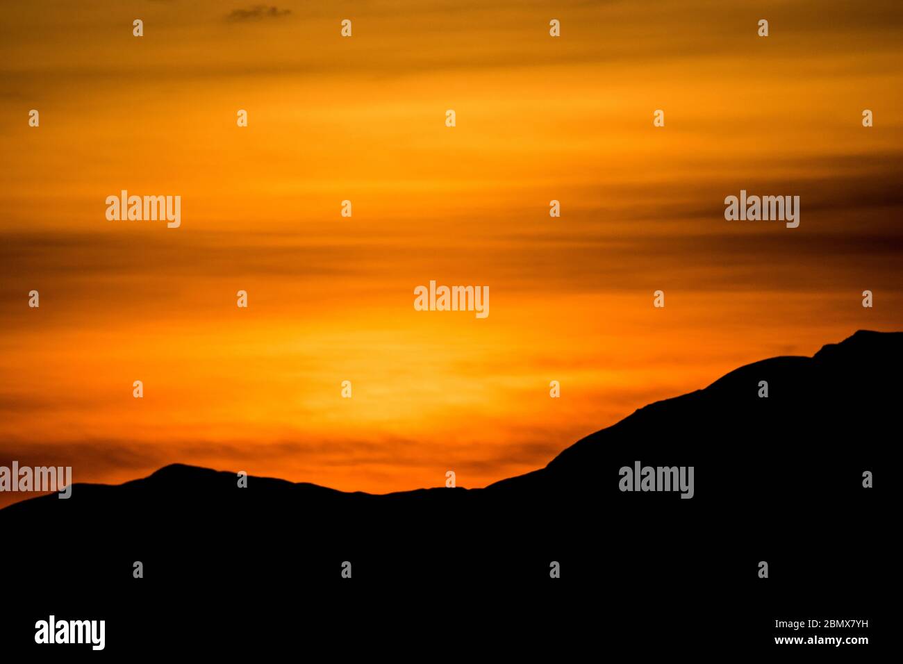 Orange sunset with fells silhouetted Stock Photo