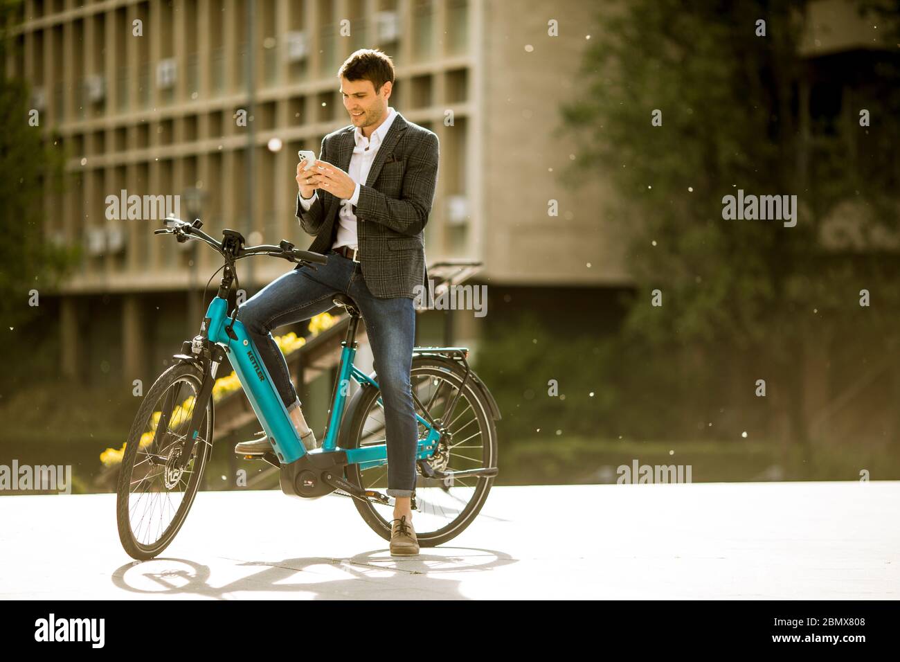 Young businessman on the Kettler Quadriga CX10 ebike with mobile phone  Stock Photo - Alamy