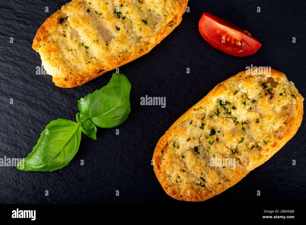Fried bread with olive oil and herbs on a dark slate Stock Photo